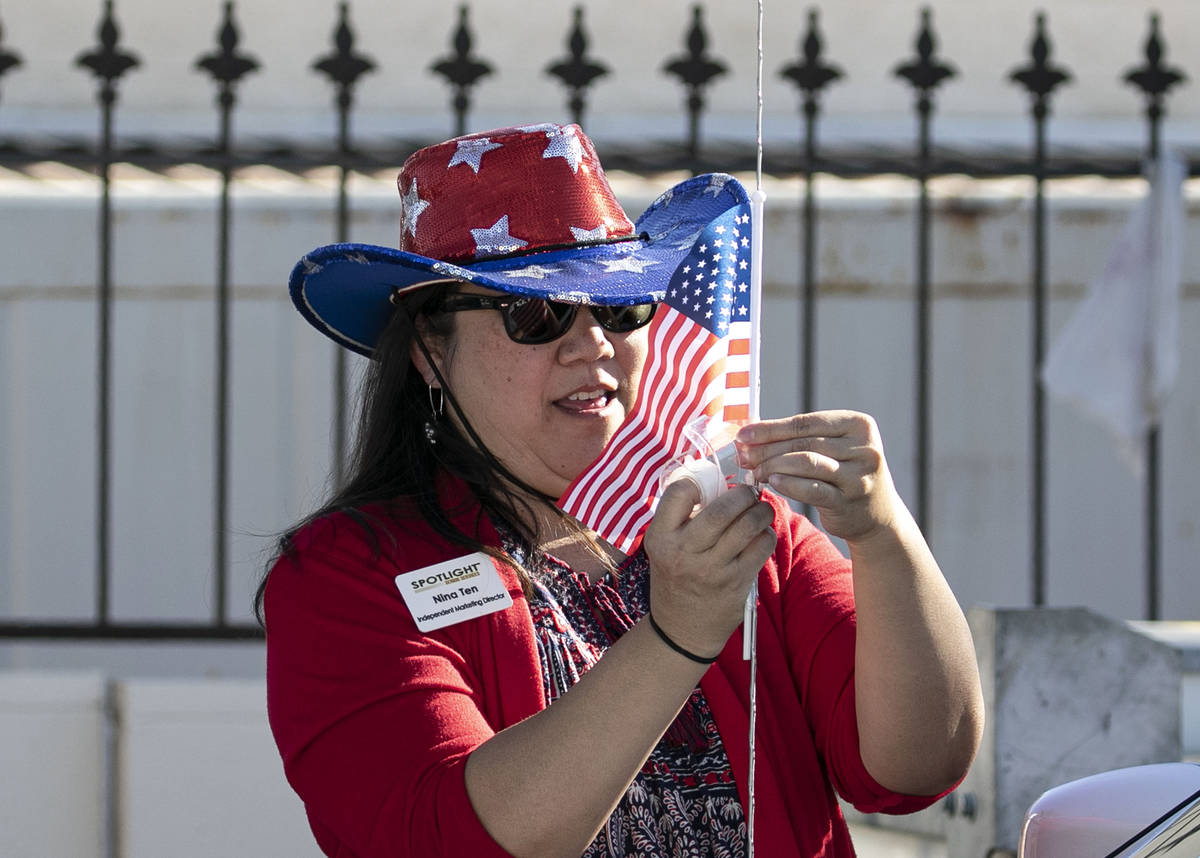 Nina Ten, independent marketing director for Spotlight Senior Services, places an American flag ...