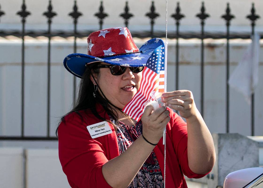 Nina Ten, independent marketing director for Spotlight Senior Services, places an American flag ...