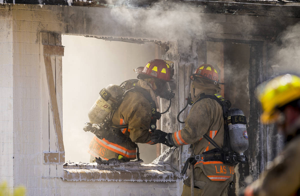 Las Vegas firefighters talks as they battle a house fire on 5400 block of West Pebble Beach Bou ...