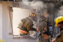 Las Vegas firefighters talks as they battle a house fire on 5400 block of West Pebble Beach Bou ...