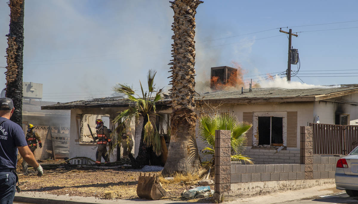 Fire continues to burn on the roof as Las Vegas firefighters battle a house fire on 5400 block ...