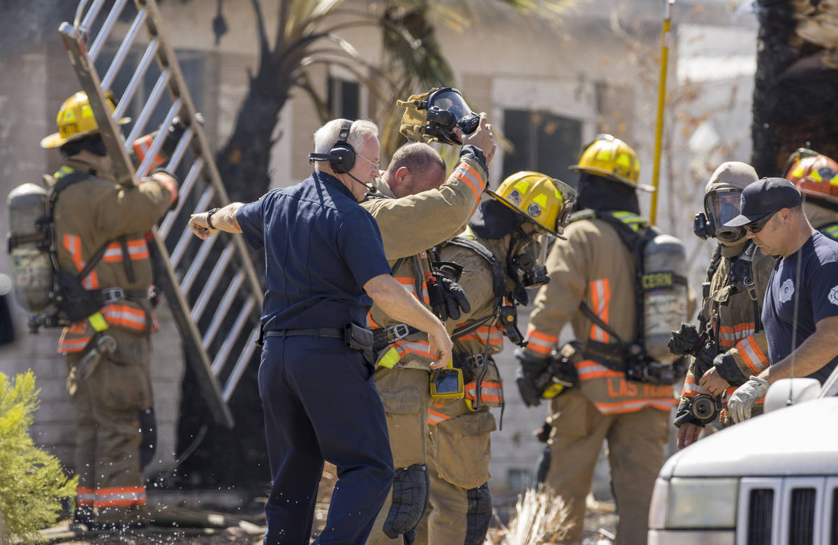Las Vegas firefighters make a plan as they battle a house fire on 5400 block of West Pebble Bea ...