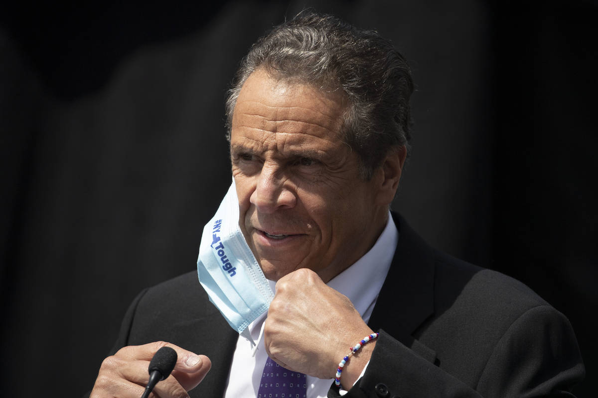 New York Gov. Andrew Cuomo removes a mask as he holds a news conference in Tarrytown, N.Y., in ...