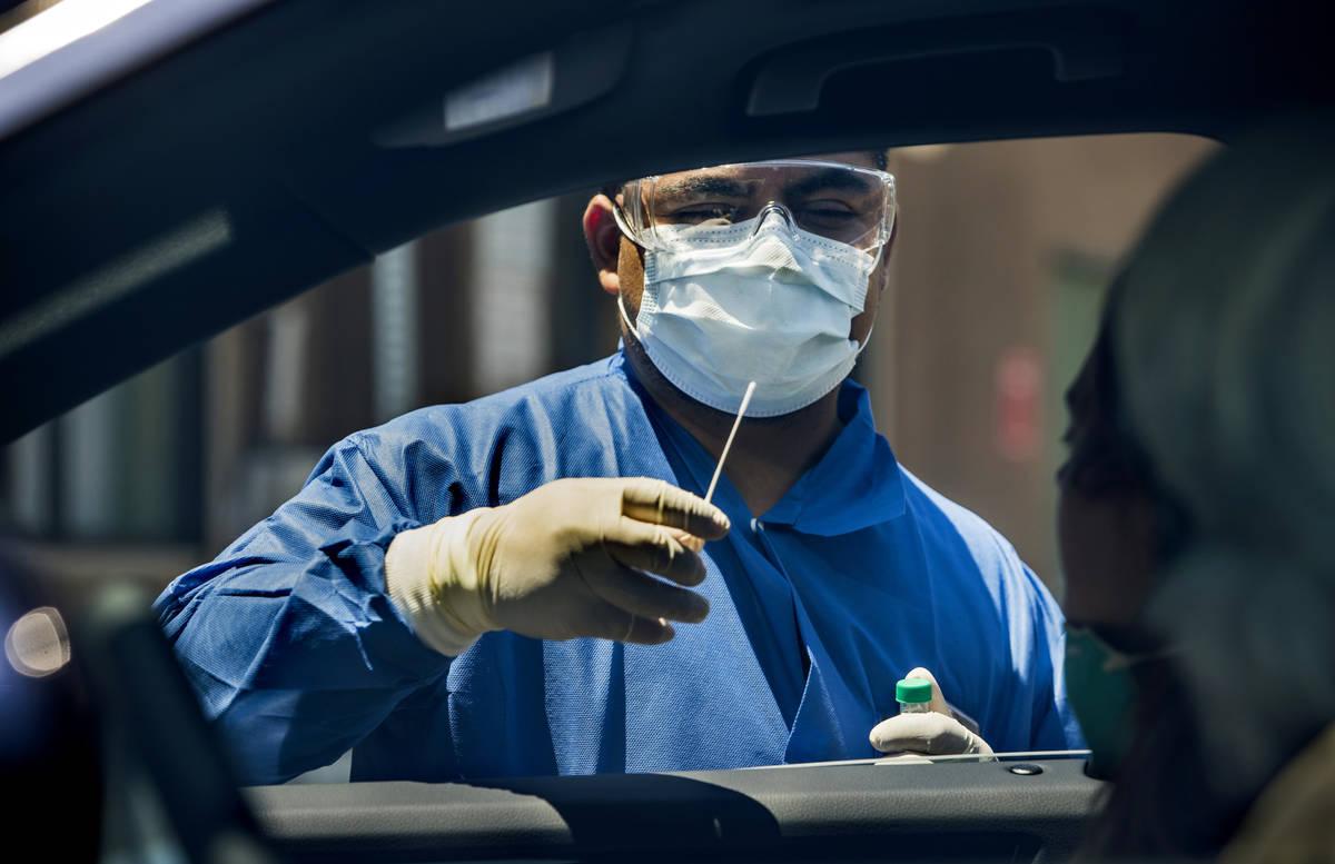 Practice Manager Jose Tirana conducts a COVID-19 test on a patient in Las Vegas, June 23, 2020. ...