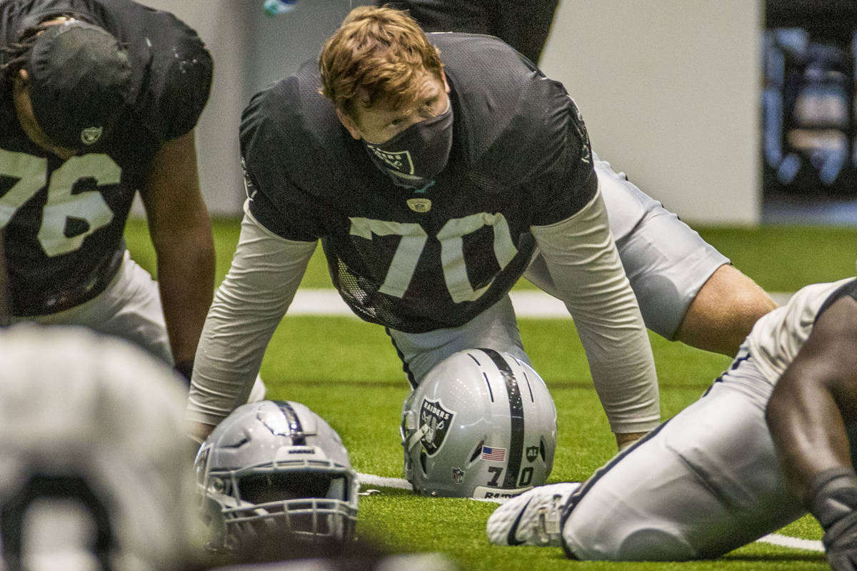 Las Vegas Raiders offensive tackle Sam Young (70 ) stretches with teammates during warm ups at ...