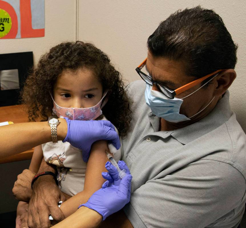 Roberto Lopez holds his daughter, Jasmin Moreno, 4, as Victoria Hodge, licensed practical nurse ...