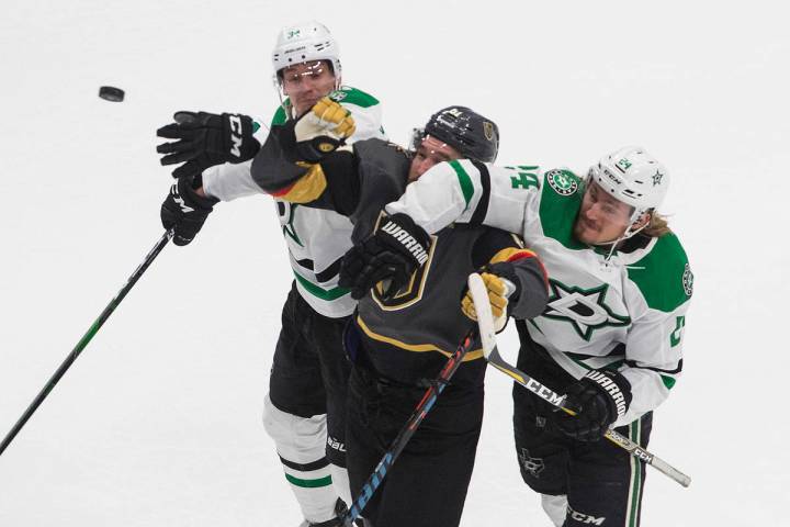 Dallas Stars' Denis Gurianov (34) and Roope Hintz (24) compete for the puck with Vegas Golden K ...