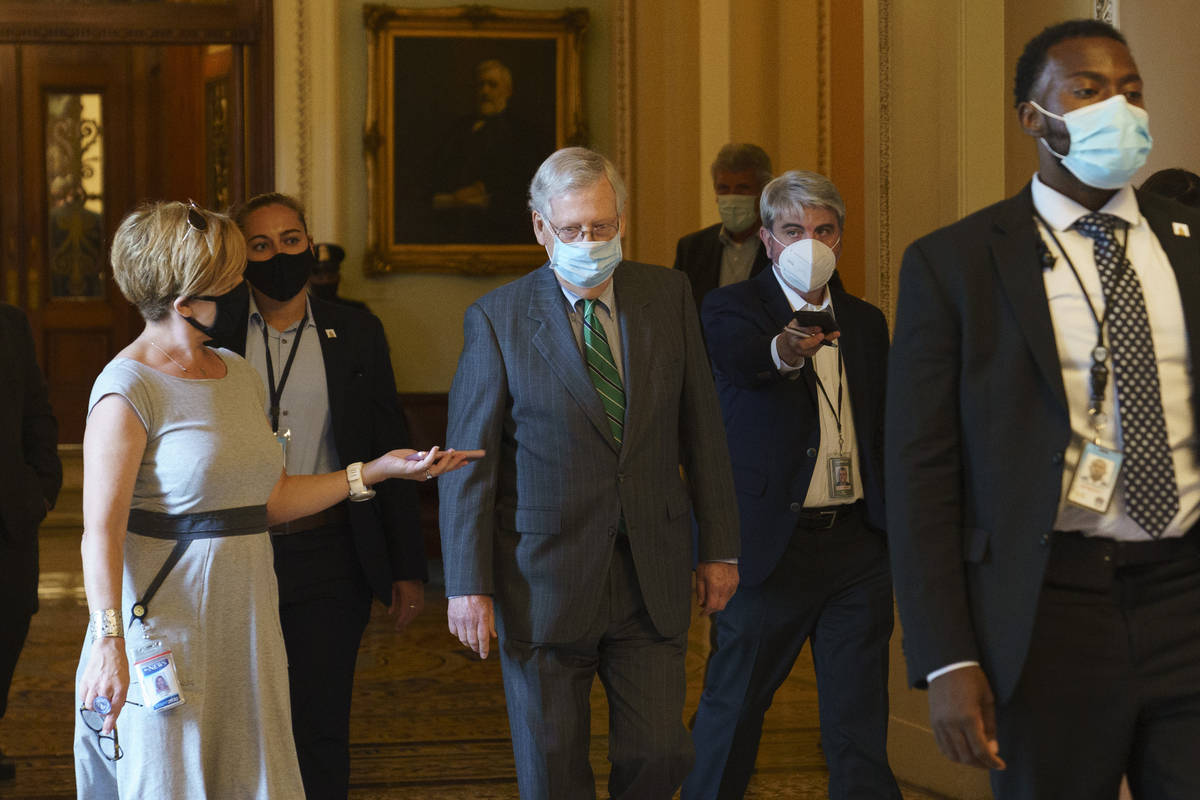 Senate Majority Leader Mitch McConnell of Ky., center, walks to his office from the Senate floo ...