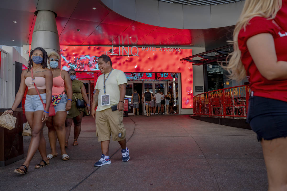 Individuals enter and exit the LINQ Hotel and Casino on the Strip on Friday, Aug. 7, 2020, in L ...