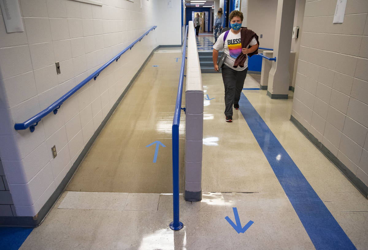 A student walks through the halls of Carlton High School on Tuesday while following the marked ...