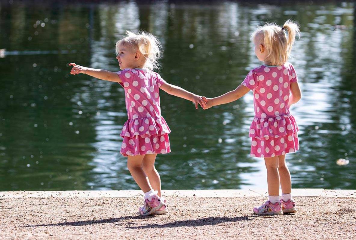 Eloise Agnew, 2, left, and her sister Penelope, 3, walk along Sunset Park pond on Thursday, Se ...