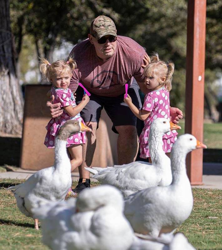 Derrick Agnew and his daughters Eloise, 2, left, Penelope, 3, watch geese at Sunset Park on Thu ...