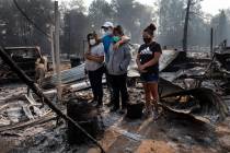 The Reyes family looks at the destruction of their home at Coleman Creek Estates mobile home pa ...