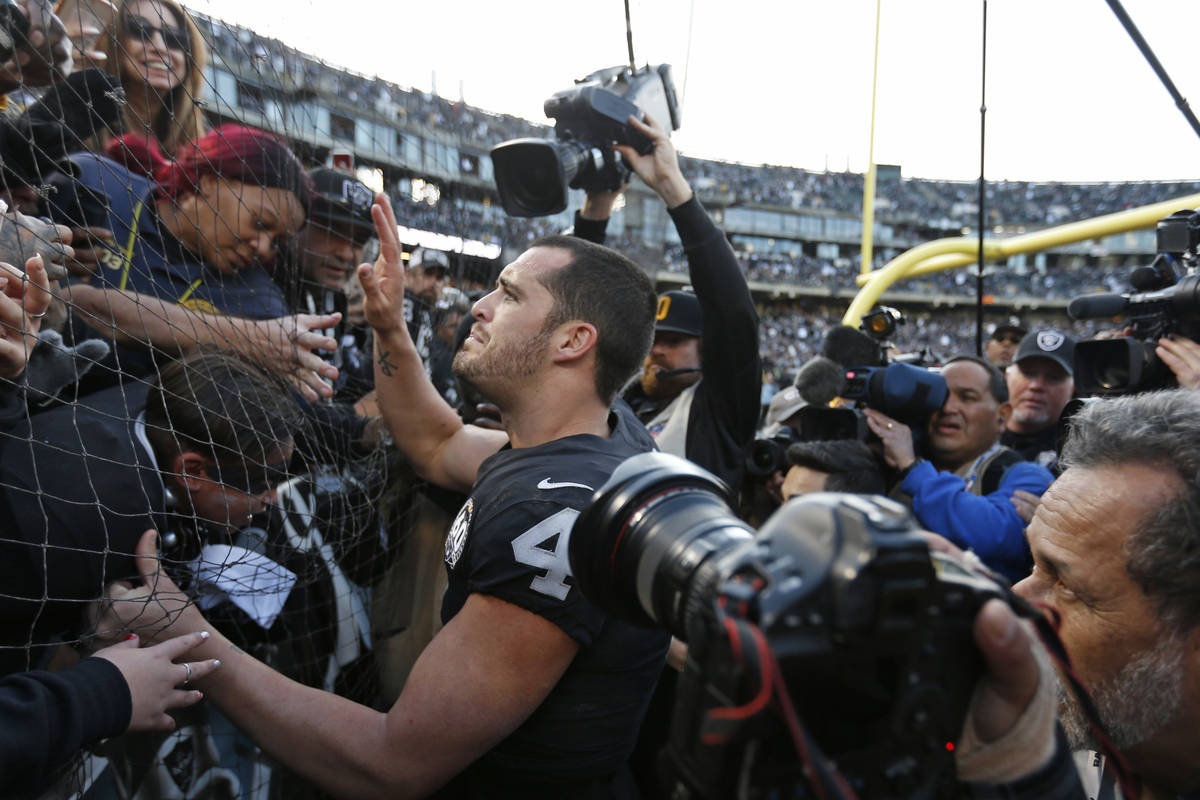 Oakland Raiders quarterback Derek Carr is greeted by fans in "The Black Hole" after a ...