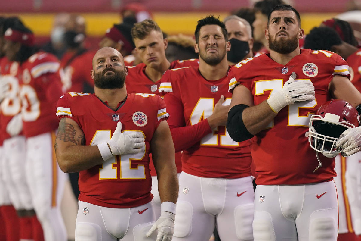 Kansas City Chiefs players stand for the national anthem before an NFL football game against th ...