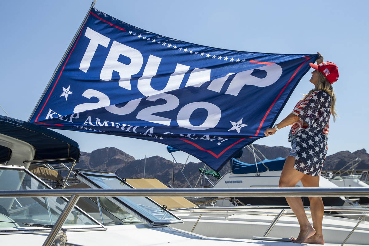 Event organizer Christine Snedden unfurls a flag as she and others prepare their boat for the P ...