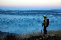 A firefighter watches during the Apple Fire in Cherry Valley, Calif., in August 2020. (AP Photo ...