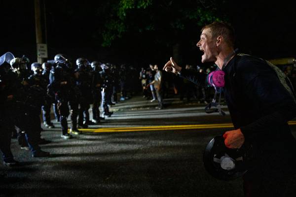 A protester screams at police as as Portland protests continue reaching 100 consecutive nights ...