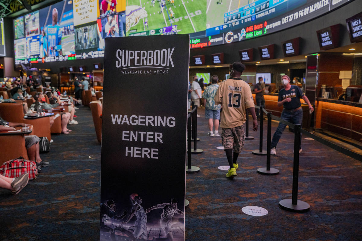 Individuals watch games and place bets at the Westgate Sportsbook during opening weekend, in La ...