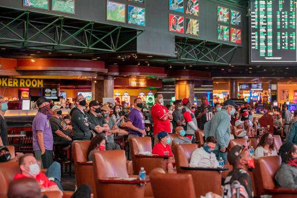 Individuals watch games at the Westgate Sportsbook during opening weekend, in Las Vegas on Sund ...