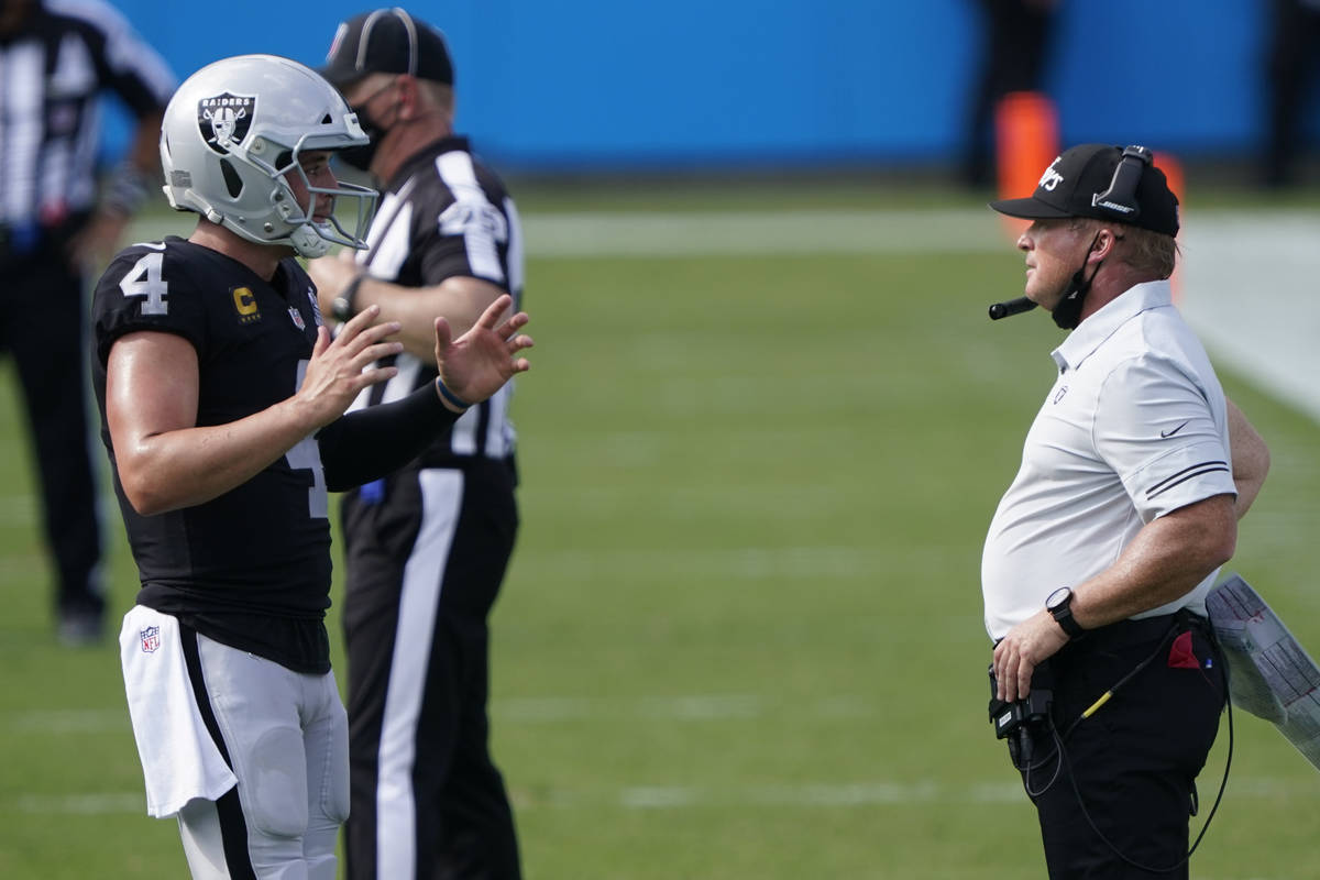 Las Vegas Raiders head coach Jon Gruden talks with quarterback Derek Carr during the second hal ...