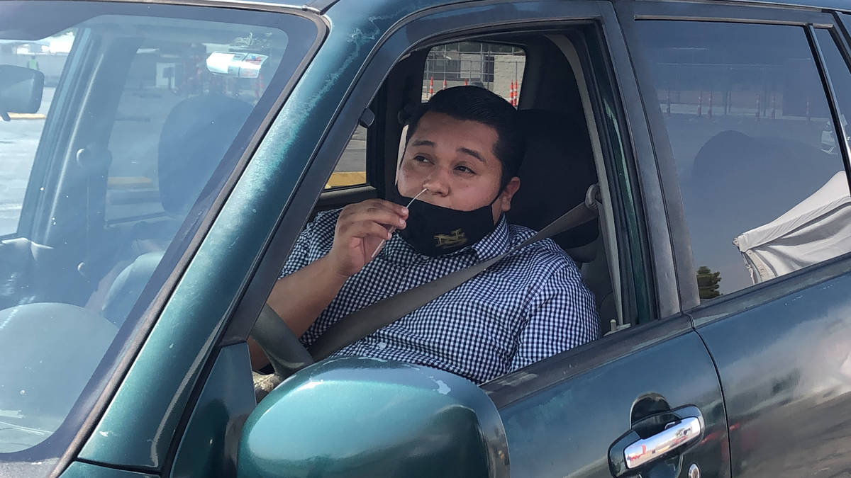 Vincent Nava swabs his nose during his COVID-19 test at the "Stop, Swab & Go!" drive-thru testi ...