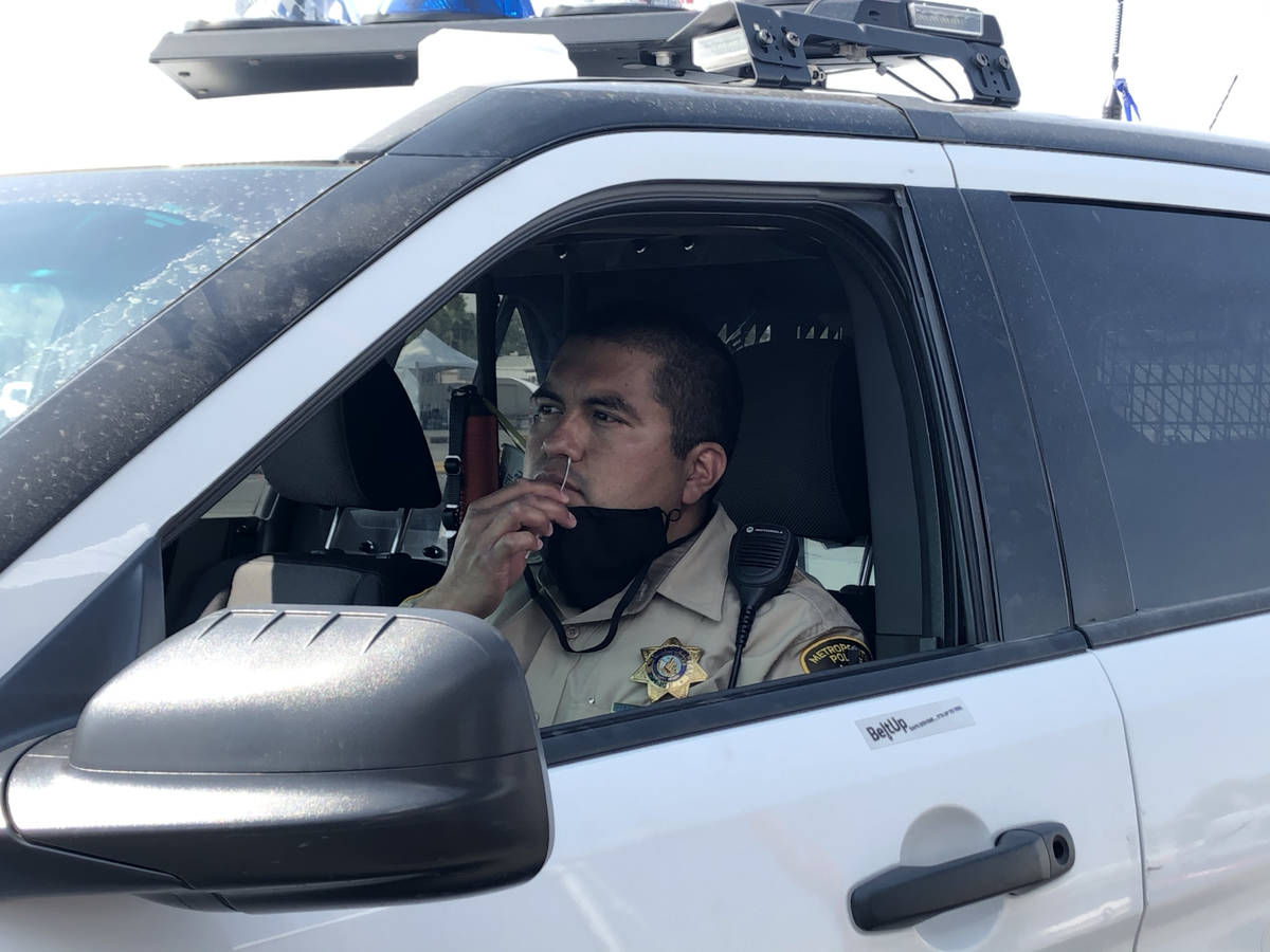 Metro officer Sam Diaz does his COVID-19 test at the "Stop, Swab & Go!" drive-thru testing site ...