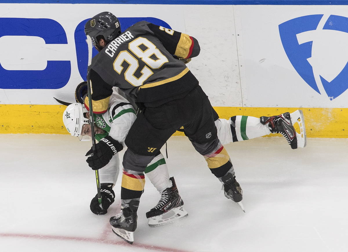 Dallas Stars' Jason Dickinson (18) is checked by Vegas Golden Knights' William Carrier (28) dur ...