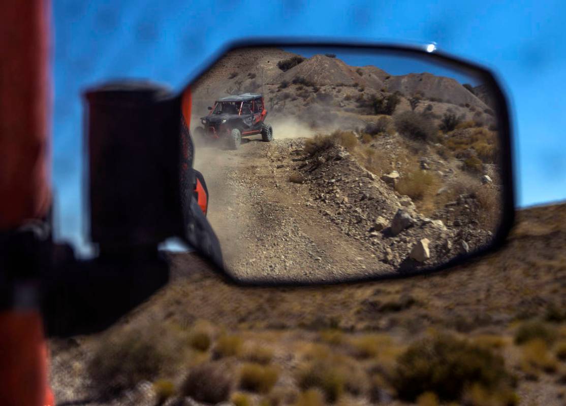 A Honda Talon is reflected in the mirror of another as the vehicles move along the miles of dir ...