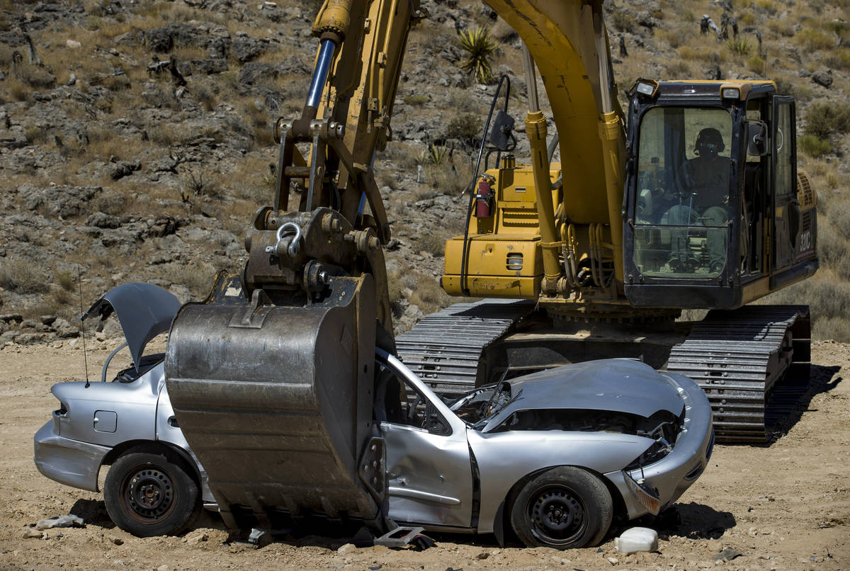 Christopher Lawrence crushes a car with the use of a Caterpillar Excavator, one of the extreme ...