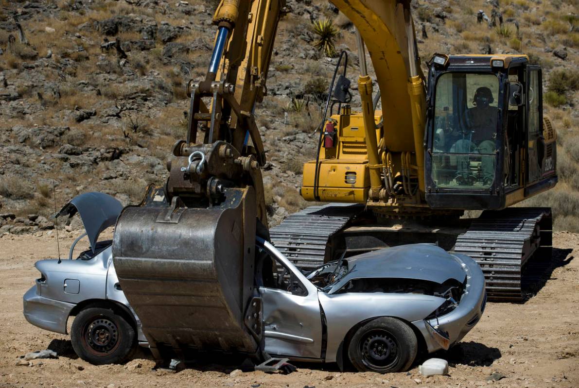 Christopher Lawrence crushes a car with the use of a Caterpillar Excavator, one of the extreme ...