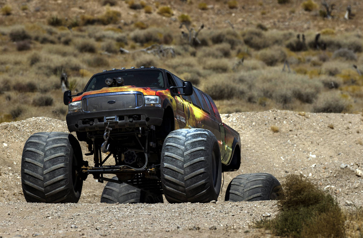 BIG GUNS, the world's longest monster truck, digs in the dirt while navigating a hill at Adrena ...