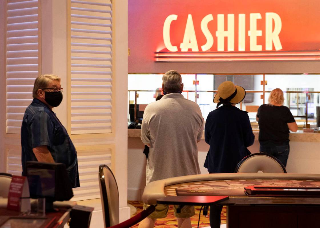 Gusts lined up at cashier booth after the Tropicana hotel-casino reopens to public, on Thursday ...