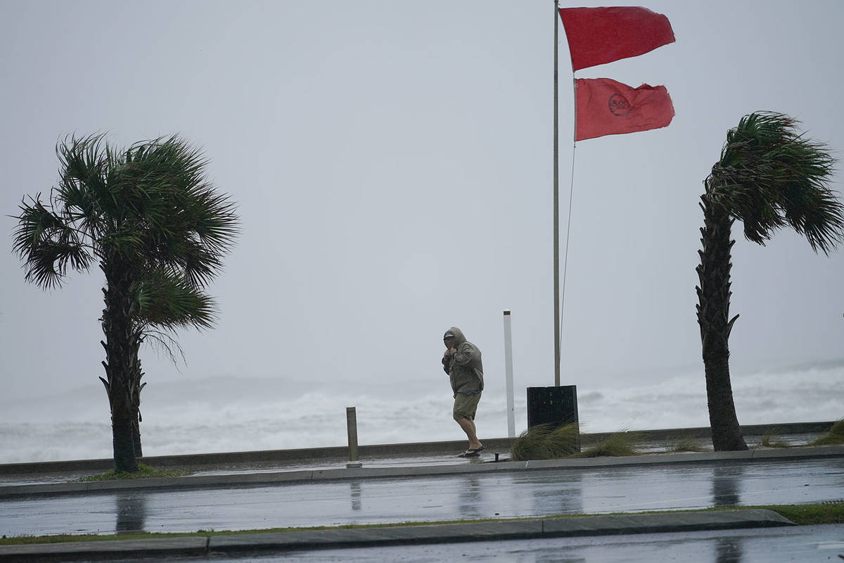 A man walks bear the gulf as Hurricane Sally moves in, Tuesday, Sept. 15, 2020, in Gulf Shores, ...