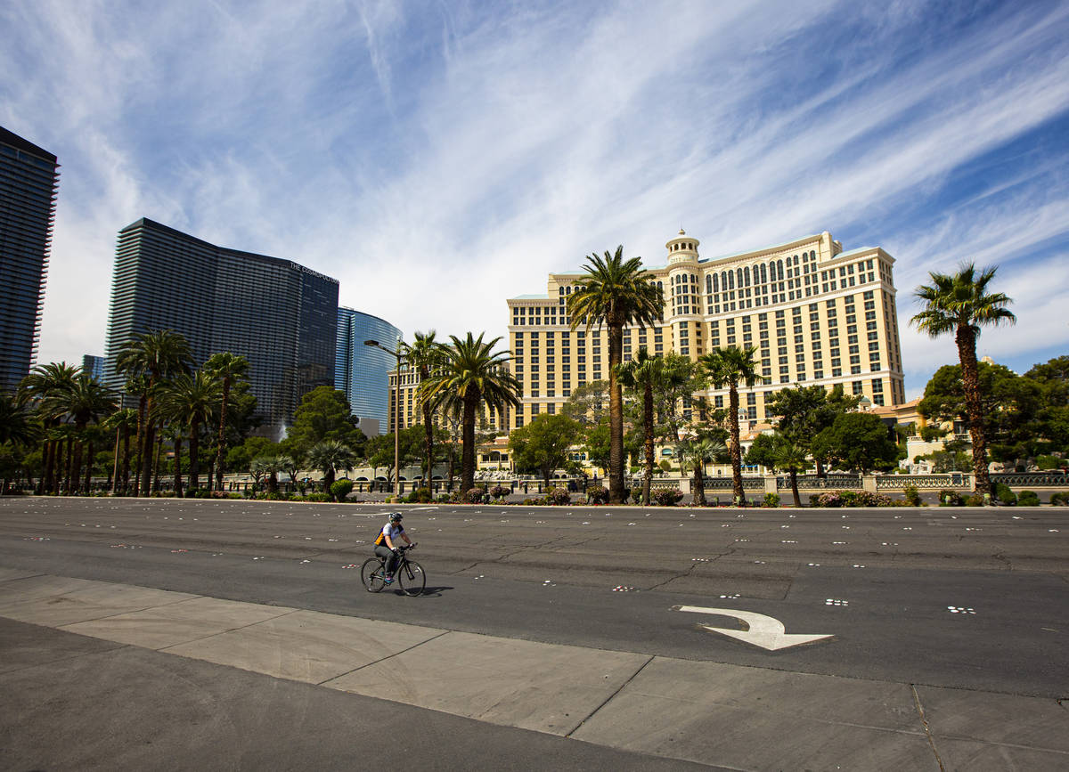 A cyclist makes their way past the Bellagio along the Las Vegas Strip on Thursday, April 16, 20 ...