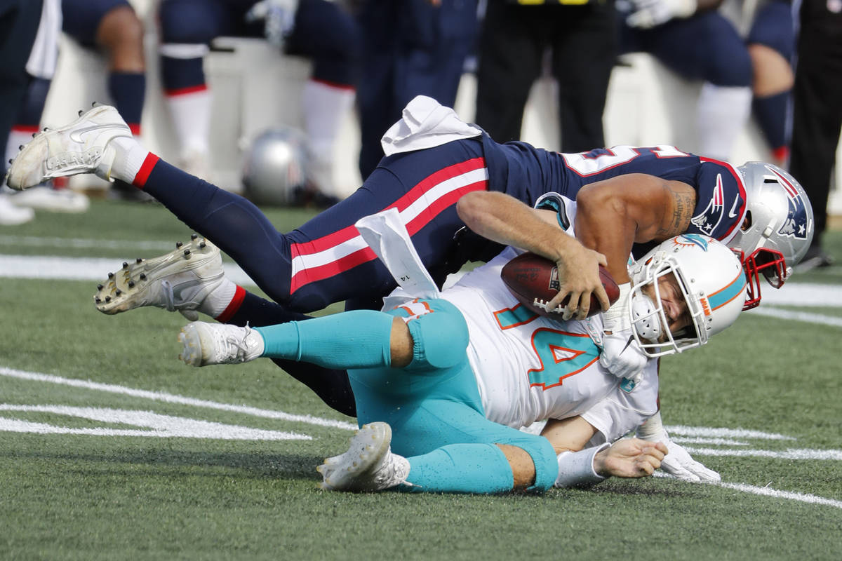 Miami Dolphins quarterback Ryan Fitzpatrick is sacked by New England Patriots defensive end Der ...