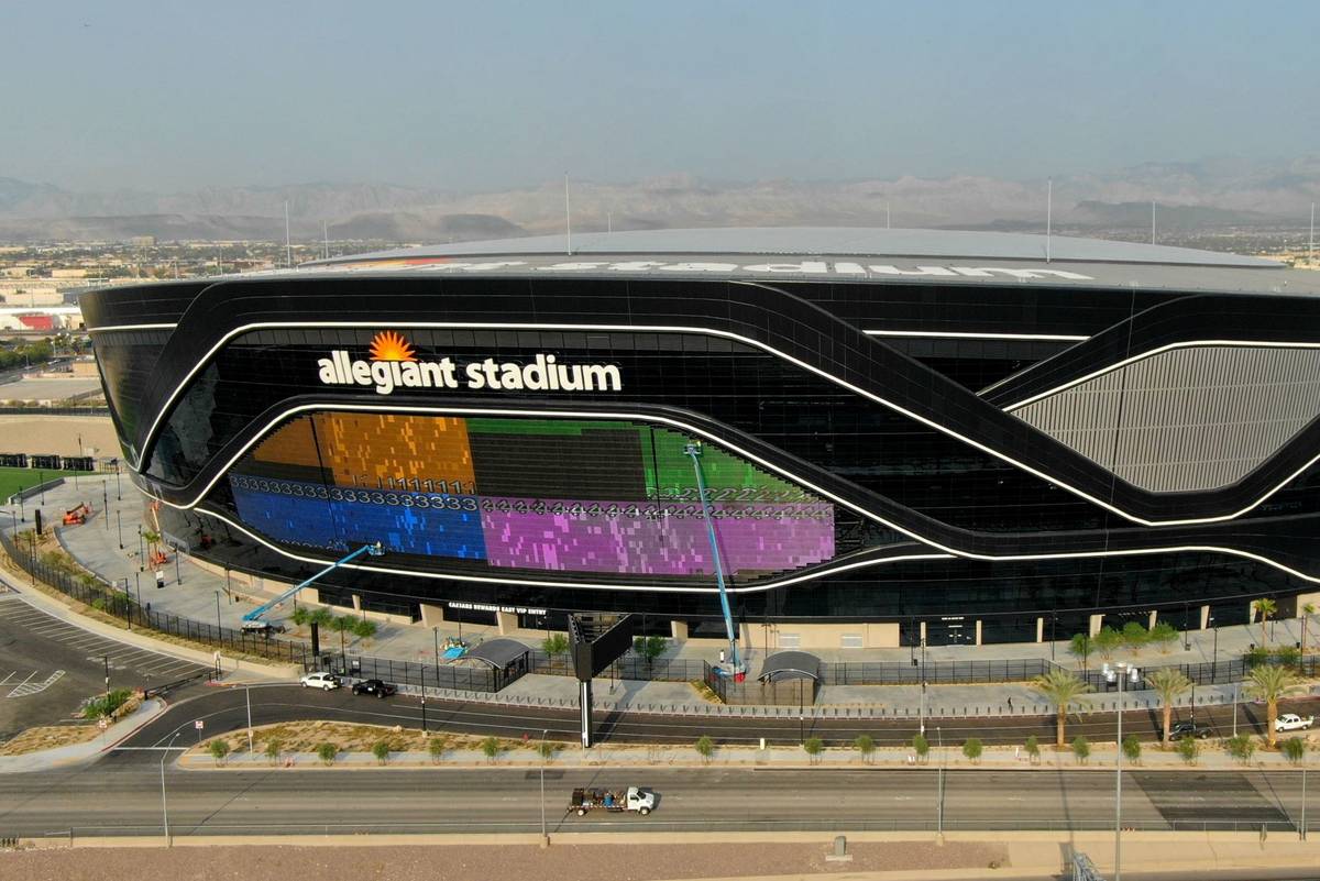 The massive 27,600-square-foot video board lights up with color on side of Allegiant Stadium th ...