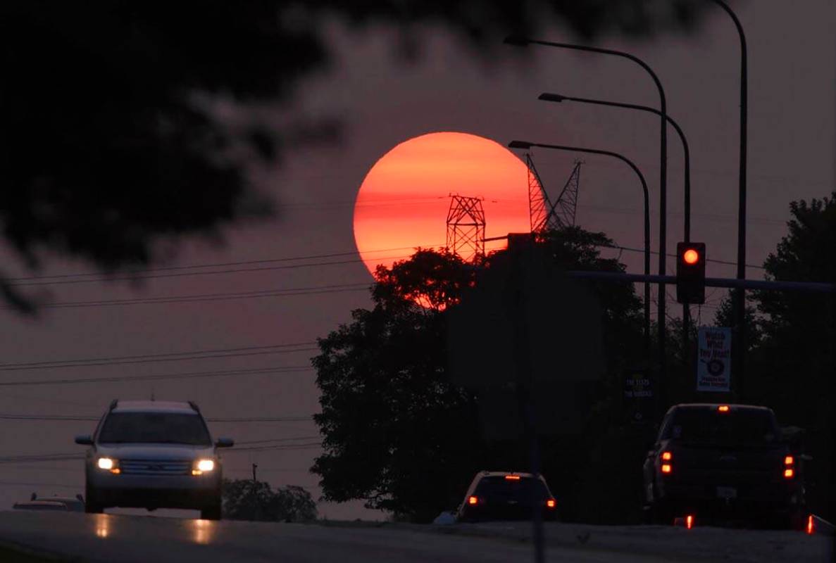 Traffic flows on Townline Road as a hazy sun sets in Vernon Hills, Ill,, Tuesday, Sept. 15, 202 ...