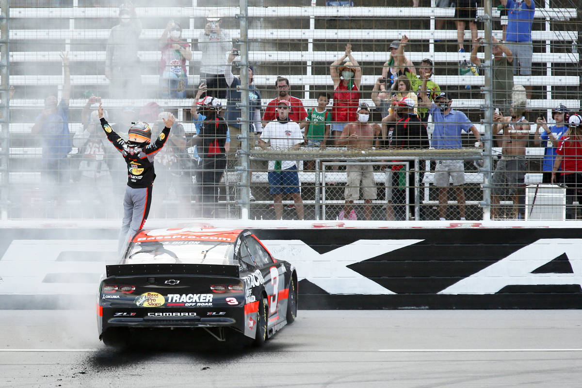 Austin Dillon stands on his car in the front stretch after winning a NASCAR Cup Series auto rac ...