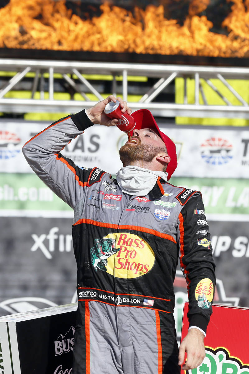 Austin Dillon takes a drink as he stands on his car in Victory Lane after winning a NASCAR Cup ...