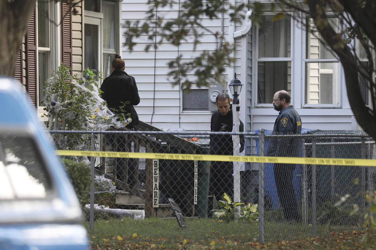 Rochester police look over the area of a home after a fatal shooting at a backyard house party, ...