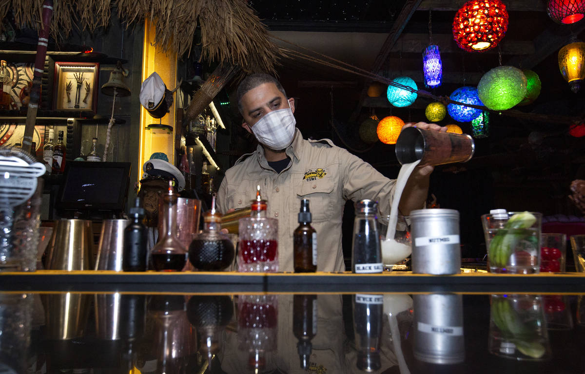 Bartender Jason Reyes poors a tiki cocktail on the first night that bars reopened since coronav ...