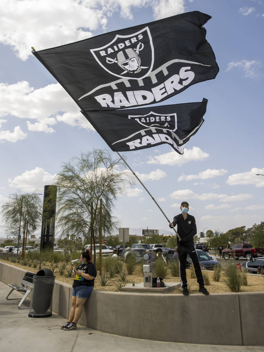 Las Vegas Raiders fan Matt Helfst waves giant flags as he and others gather outside several hou ...
