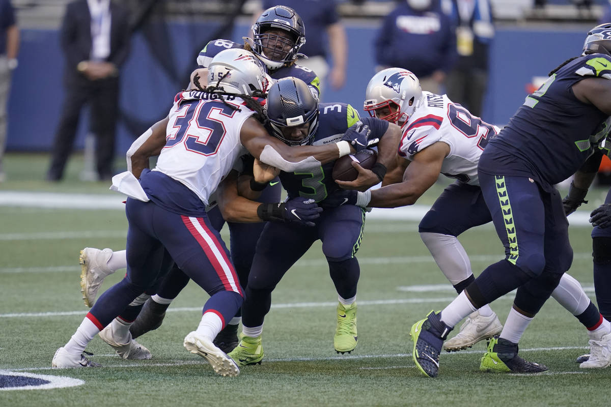 Seattle Seahawks quarterback Russell Wilson is tackled by New England Patriots safety Kyle Dugg ...
