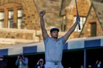 Bryson DeChambeau, of the United States, reacts after sinking a putt for par on the 18th hole t ...