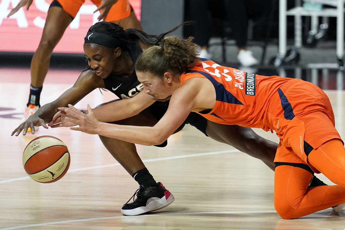 Las Vegas Aces guard Jackie Young (0) and Connecticut Sun forward Theresa Plaisance (55) chase ...