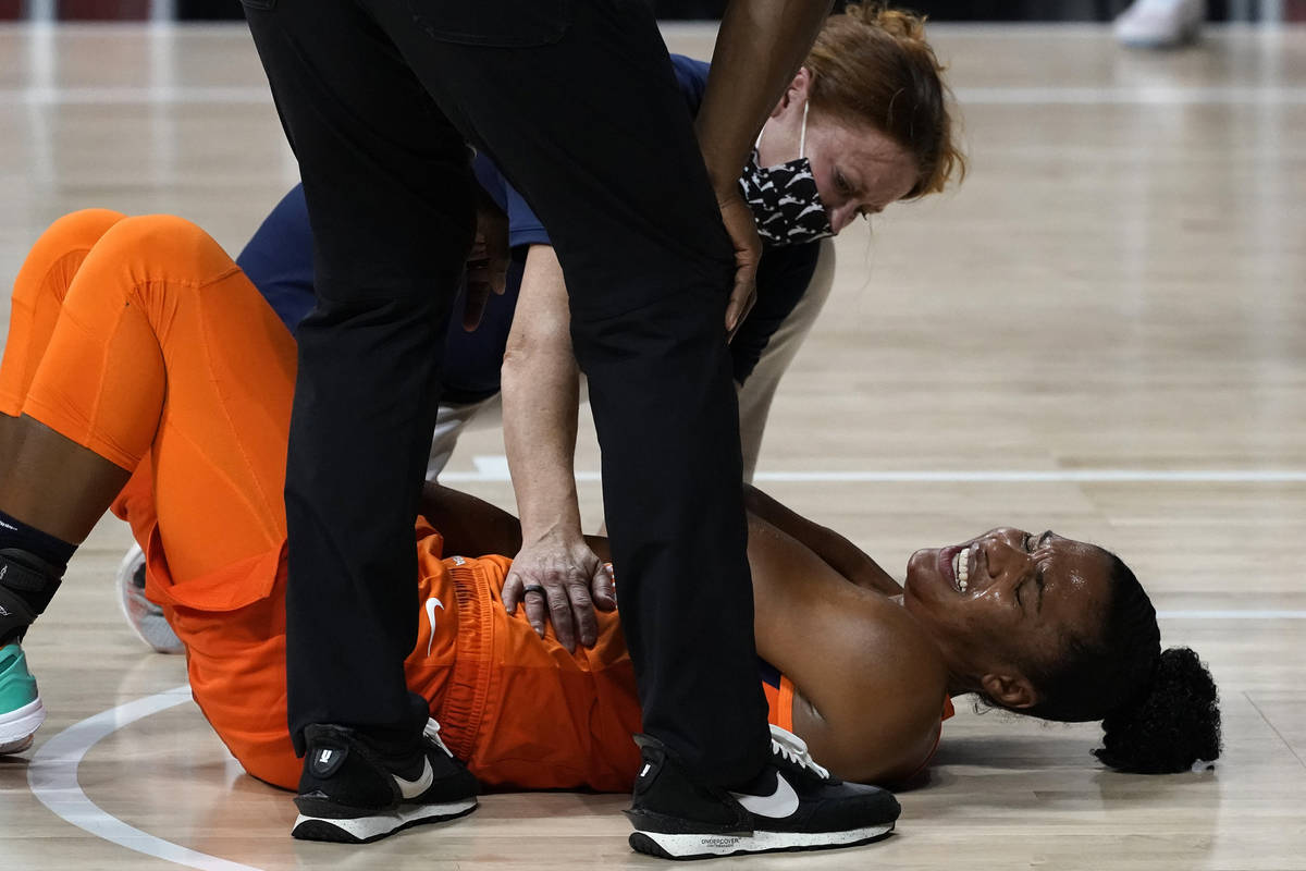 A trainer helps Connecticut Sun forward Alyssa Thomas (25) after she was hurt against the Las V ...