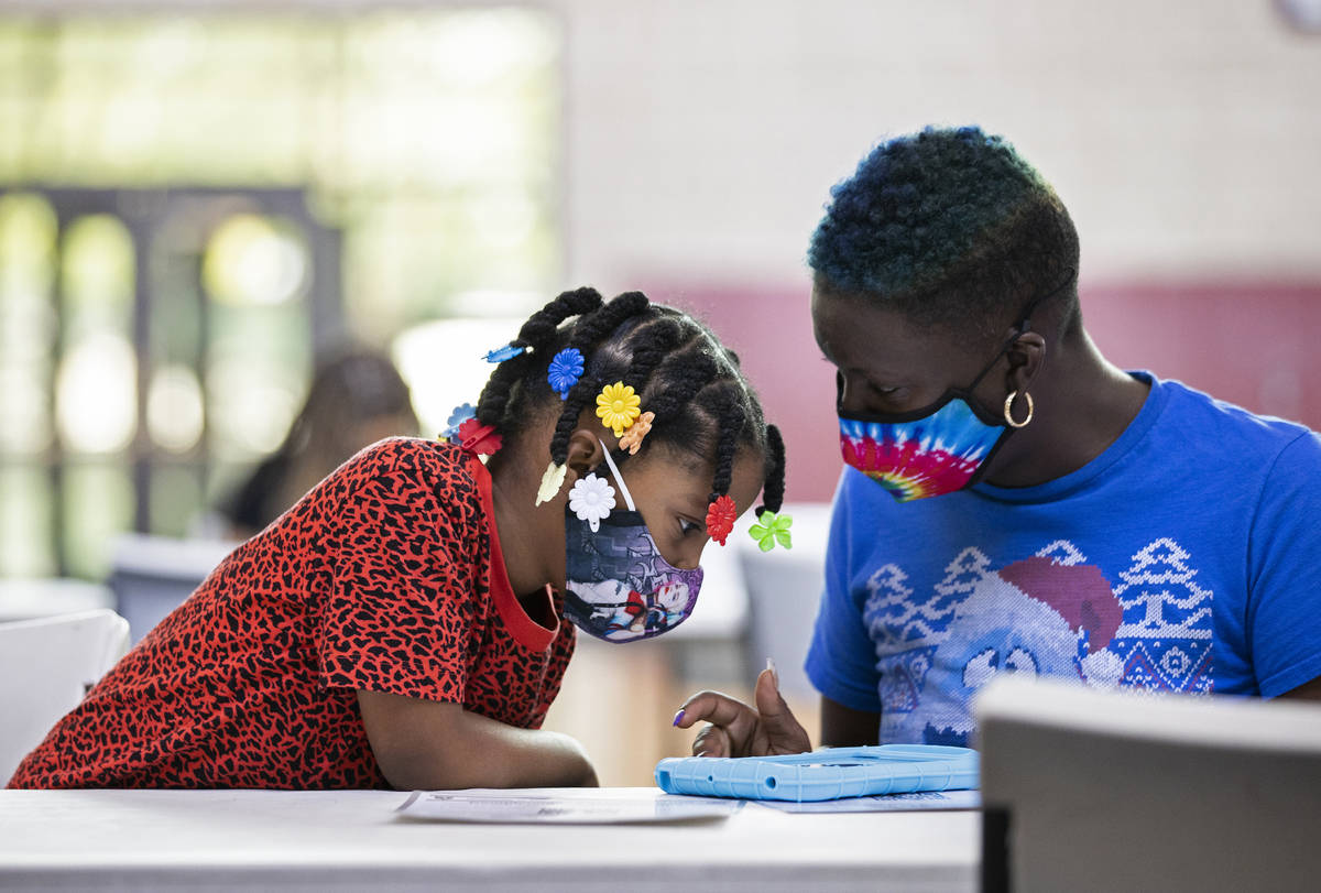 Kanita Carter, right, explains the process of registering to vote to Kimberly Moore, 7, during ...
