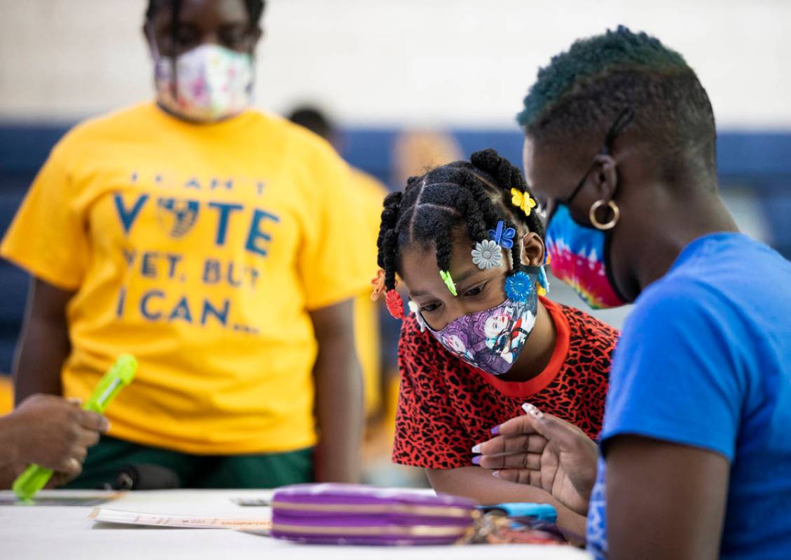 Kanita Carter, right, explains the process of registering to vote to Kimberly Moore, 7, during ...