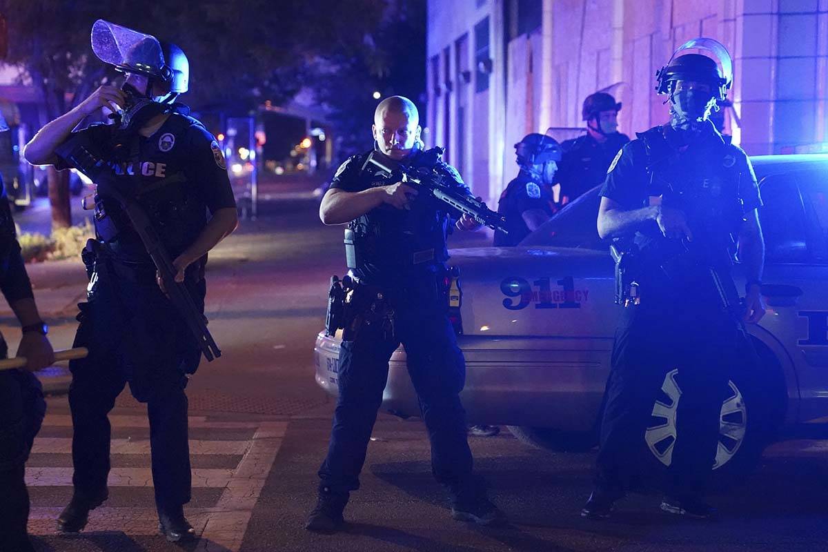 Police stand at an intersection after an officer was shot, Wednesday, Sept. 23, 2020, in Louisv ...
